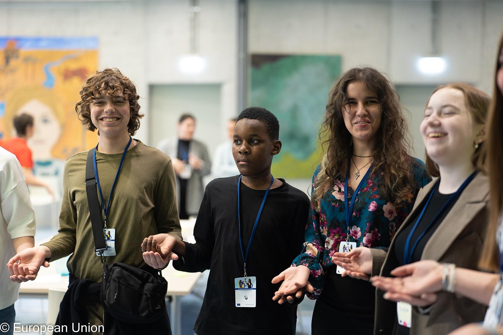 Four young people enjoying a warm-up activity during a workshop.
